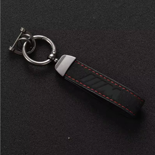 Premium black leather M-logo keychain featuring red stitching and durable metal hardware, ideal for car enthusiasts.