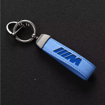 Premium blue M-logo leather keychain with stitched edges and heavy-duty metal hardware, ideal for car enthusiasts and accessories.
